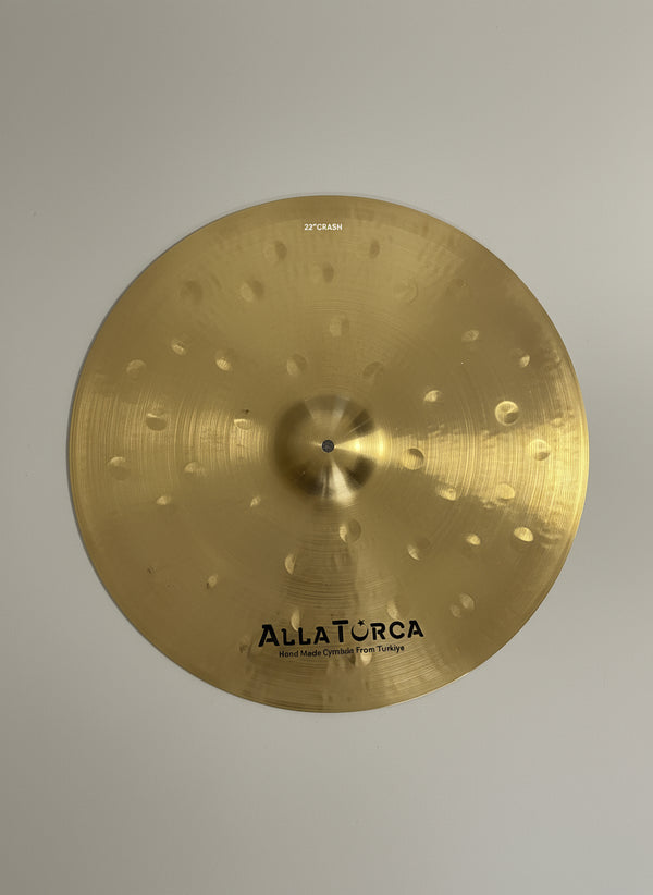 Gold cymbal with 'Allaterra' branding on a dark textured background